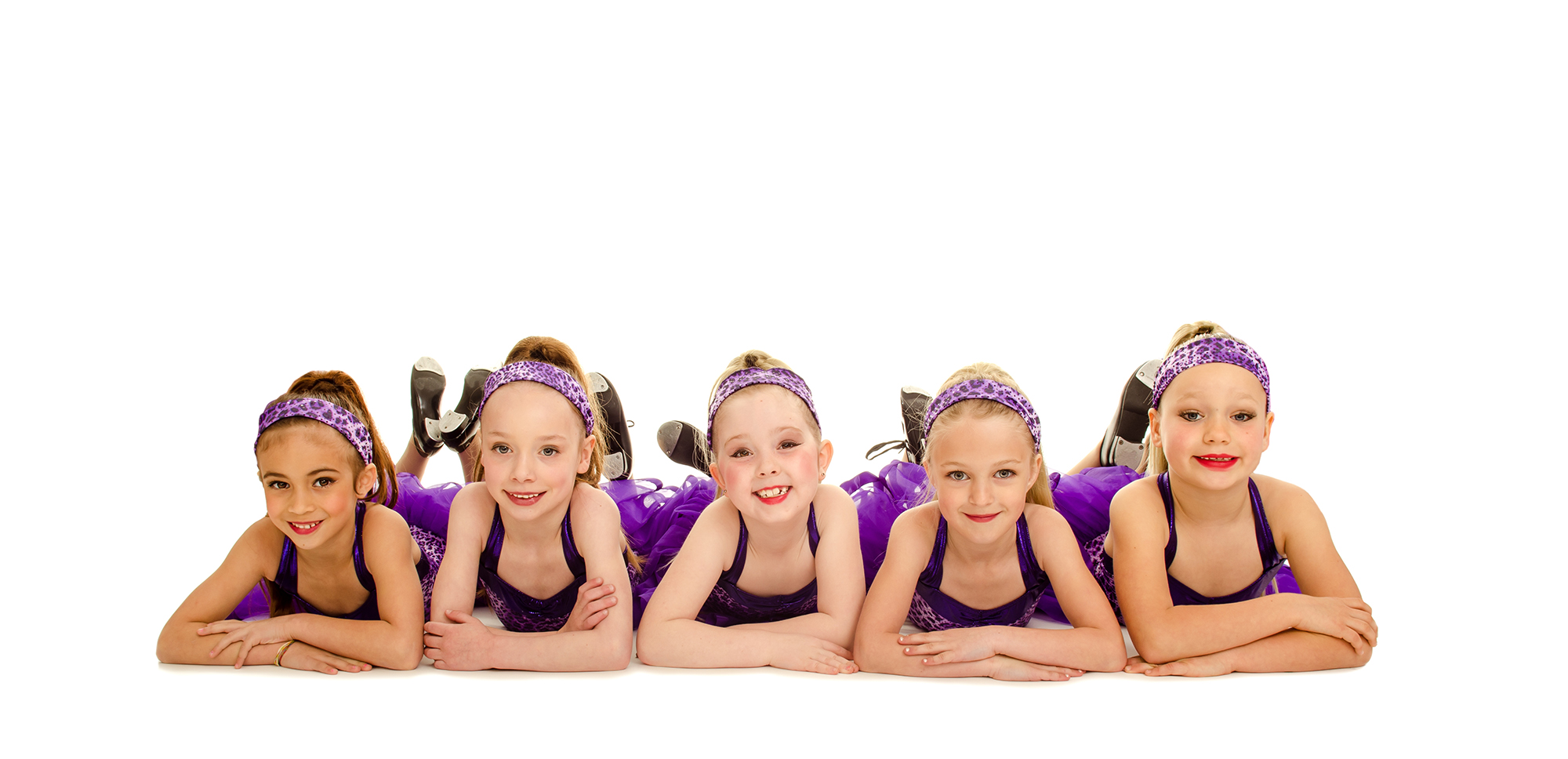 young dancers in matching costumes laying across the floor